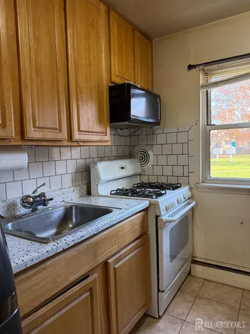 a kitchen with granite countertop a sink stove and cabinets