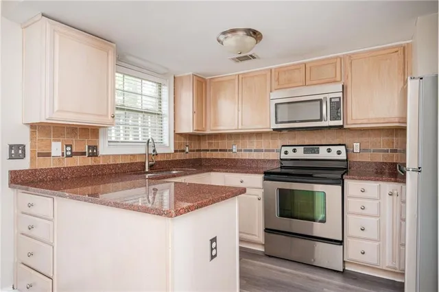 a kitchen with stainless steel appliances granite countertop a sink stove microwave and cabinets