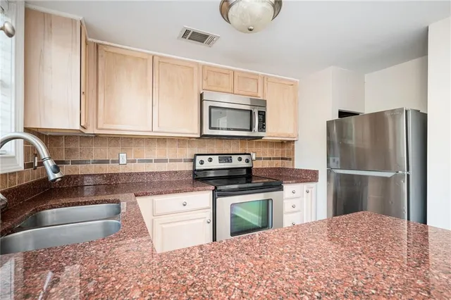 a kitchen with granite countertop a refrigerator stove and microwave