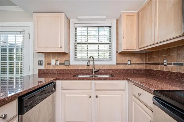 a kitchen with granite countertop a sink stove and cabinets
