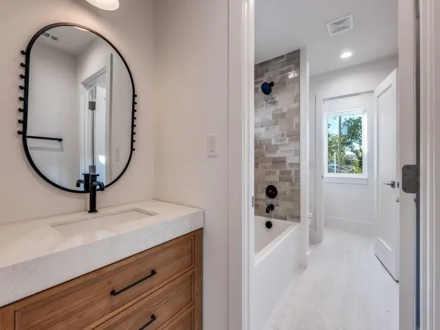 an empty room with wooden floor ceiling fan and windows