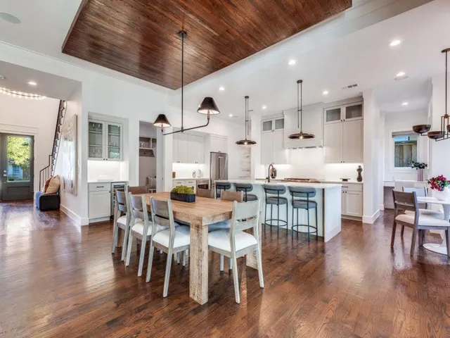 a kitchen with stainless steel appliances granite countertop a stove a sink a kitchen island with a dining table and chairs