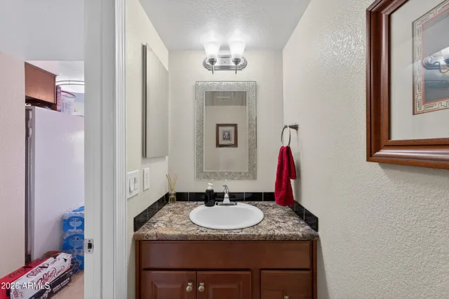 a bathroom with a granite countertop sink and a mirror
