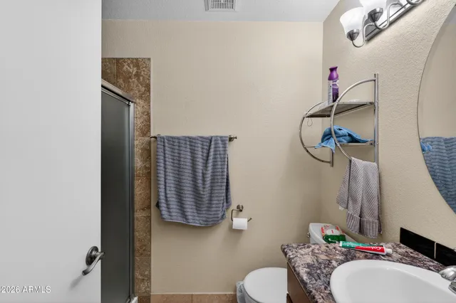 a bathroom with a sink vanity mirror and toilet
