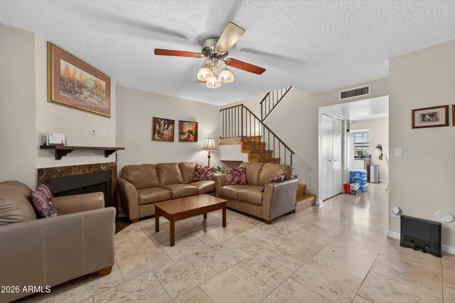 a living room with furniture and a ceiling fan