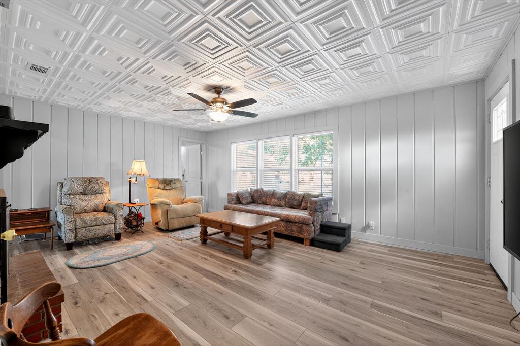 5485 Highway 7 Marlin, TX 76661 - Photo 13 of 36 Living area featuring plenty of natural light, a ceiling fan, an ornate ceiling, light wood finished floors, and wood walls