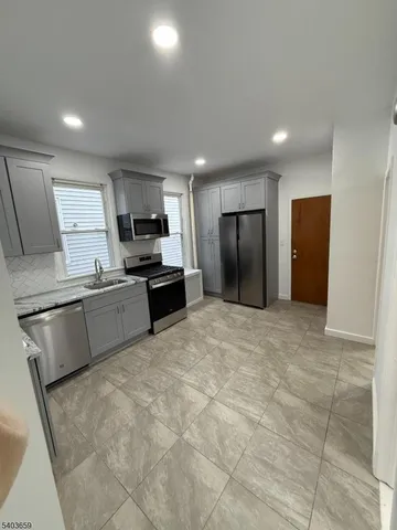 a kitchen with stainless steel appliances granite countertop a stove refrigerator and a sink