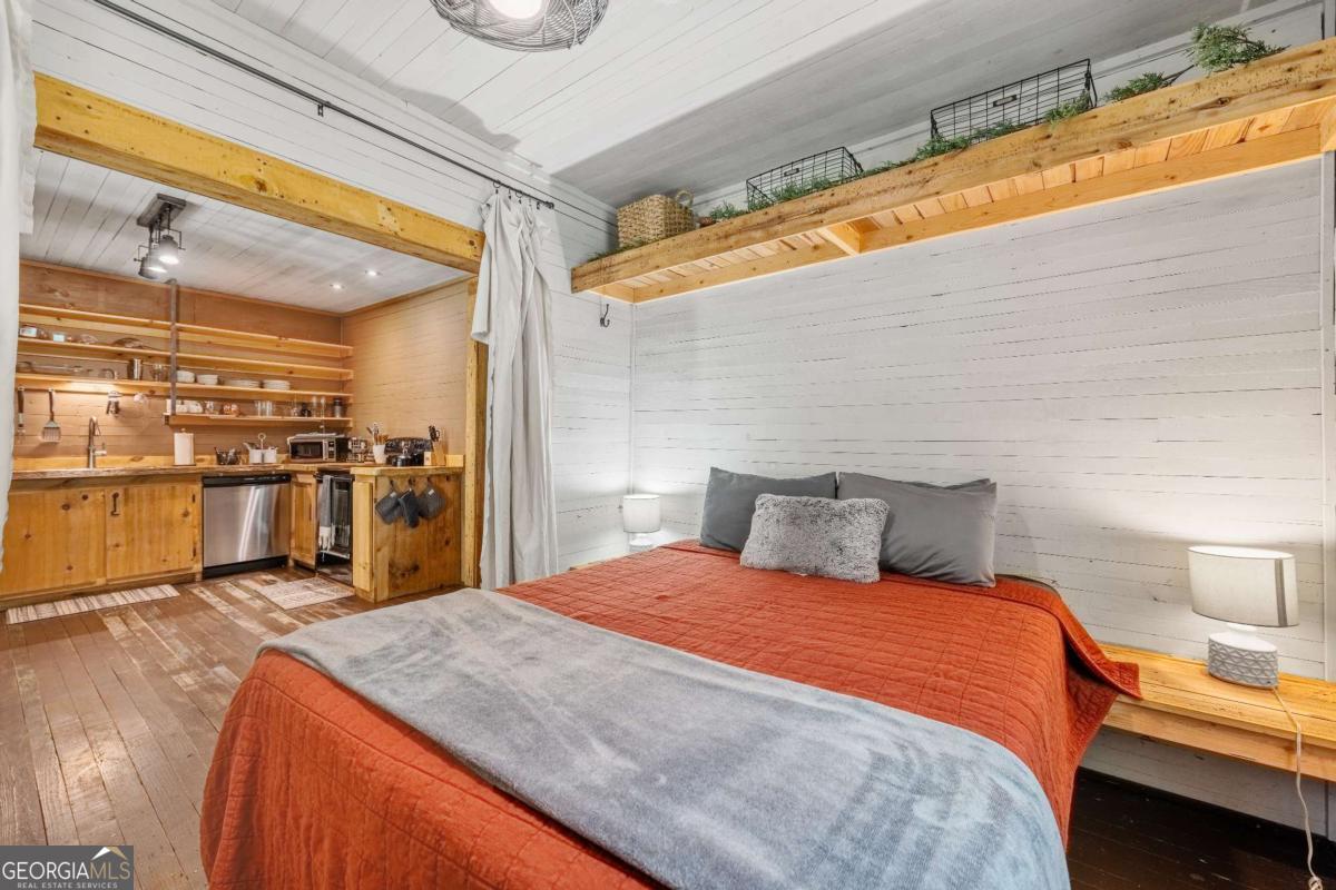 120 Community Hill Drive Blue Ridge, GA 30513 - Photo 15 of 57 a large bed sitting in a bedroom and a dining table with wooden floor