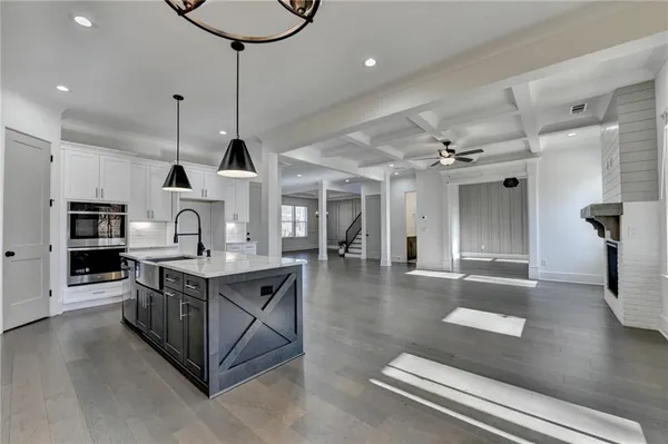 a kitchen with stainless steel appliances granite countertop a stove a sink and a wooden floors