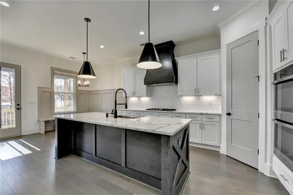 a kitchen with stainless steel appliances a sink a stove and a wooden floors