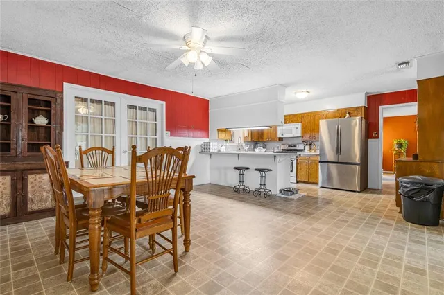 a view of kitchen with stainless steel appliances granite countertop dining table and chairs