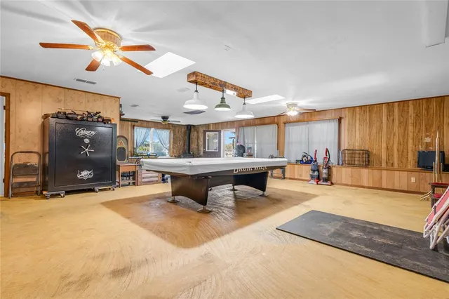 a living room with furniture a ceiling fan and a large window