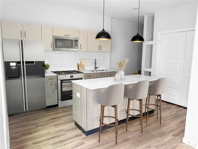 a kitchen with stainless steel appliances granite countertop a sink a stove and a refrigerator