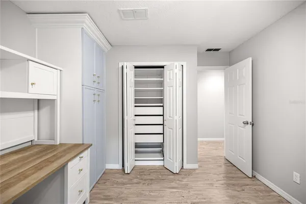 a view of a kitchen with white cabinets and wooden floor