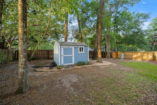 a view of a house with backyard and a tree
