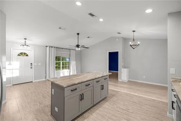 a spacious bathroom with a granite countertop sink a toilet a mirror and shower
