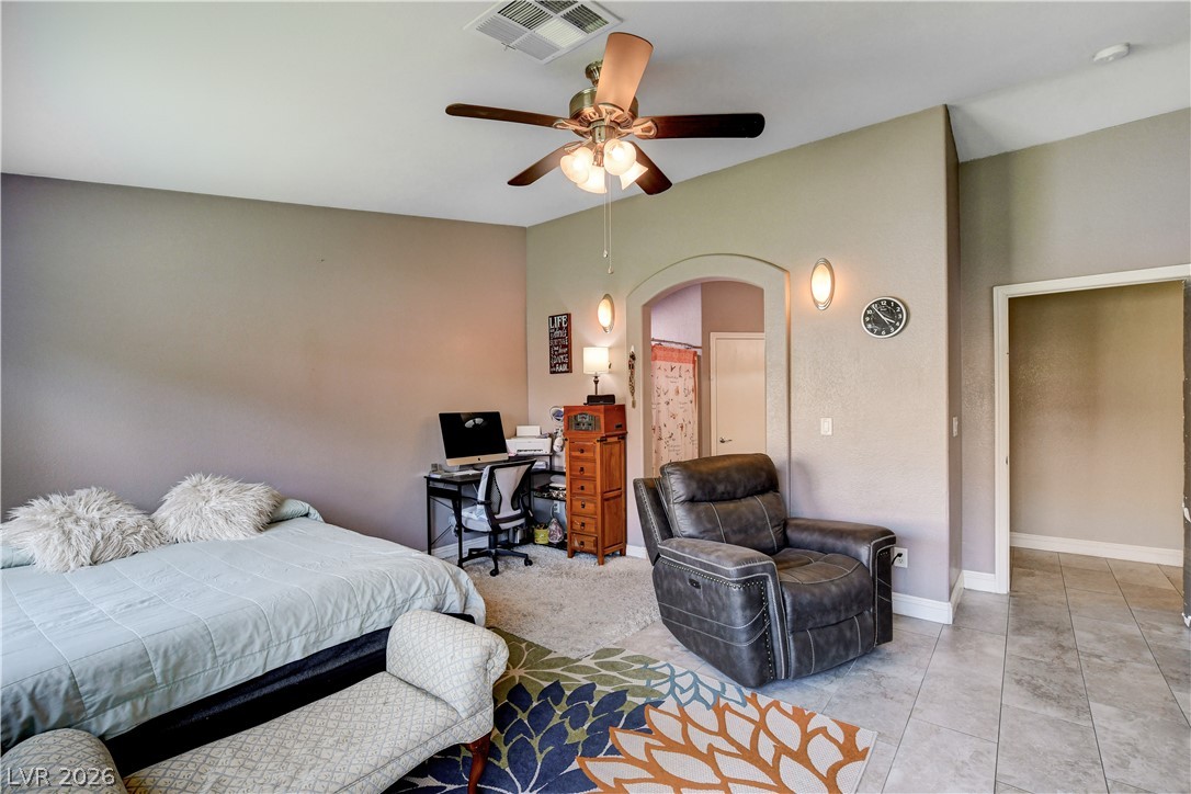 910 Cobblestone Cove Road North Las Vegas, NV 89081 - Photo 12 of 30 Well-lit living area offers a dedicated workspace and arched doorway leading to an adjacent space.