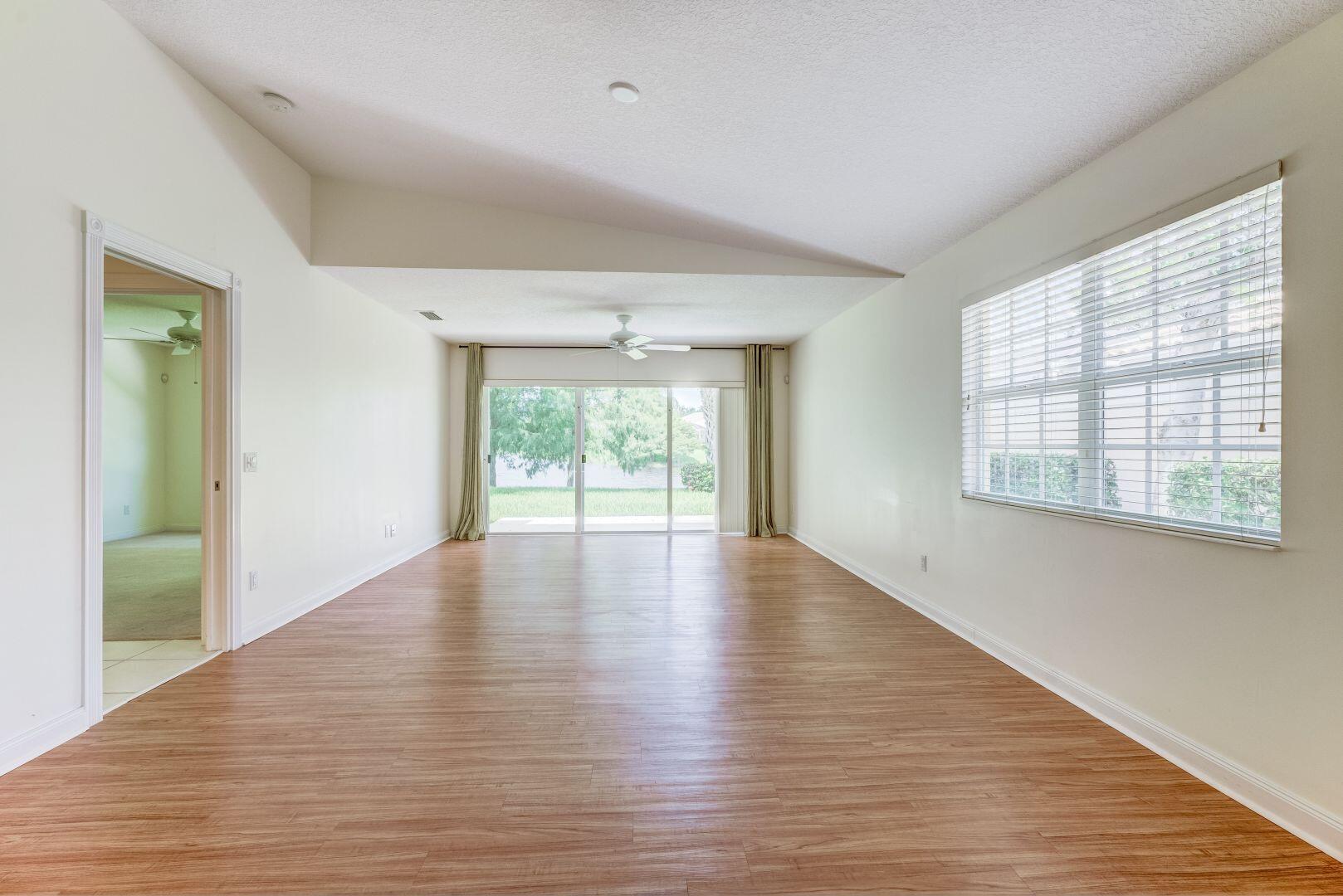 923 Magdalena Road Palm Beach Gardens, FL 33410 - Photo 19 of 47 a view of an empty room with wooden floor and a window