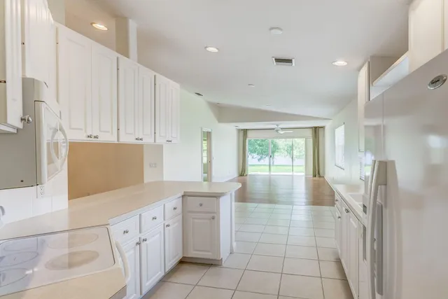 a large white kitchen with a large window