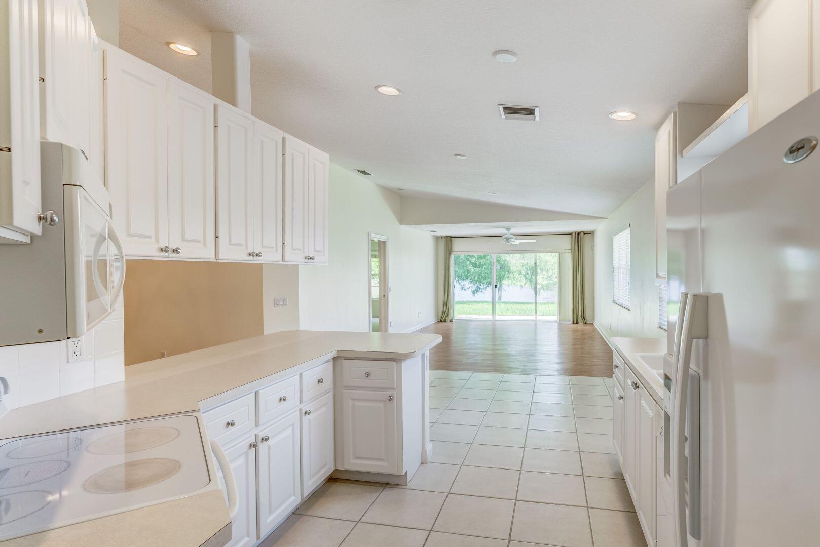 923 Magdalena Road Palm Beach Gardens, FL 33410 - Photo 24 of 47 a large white kitchen with a large window