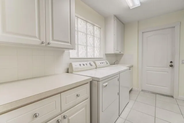 a utility room with cabinets washer and dryer