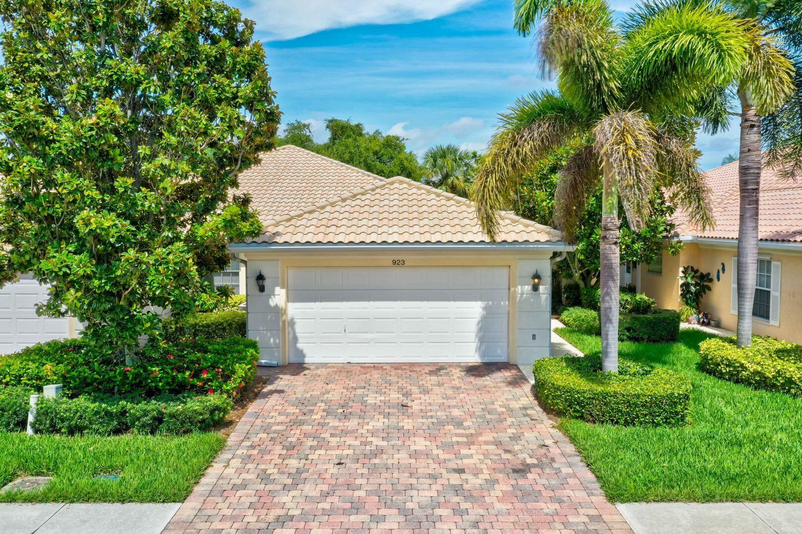 923 Magdalena Road Palm Beach Gardens, FL 33410 - Photo 36 of 47 a front view of a house with a yard and garage