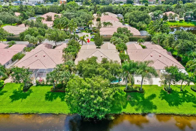 an aerial view of a house with a garden and lake view