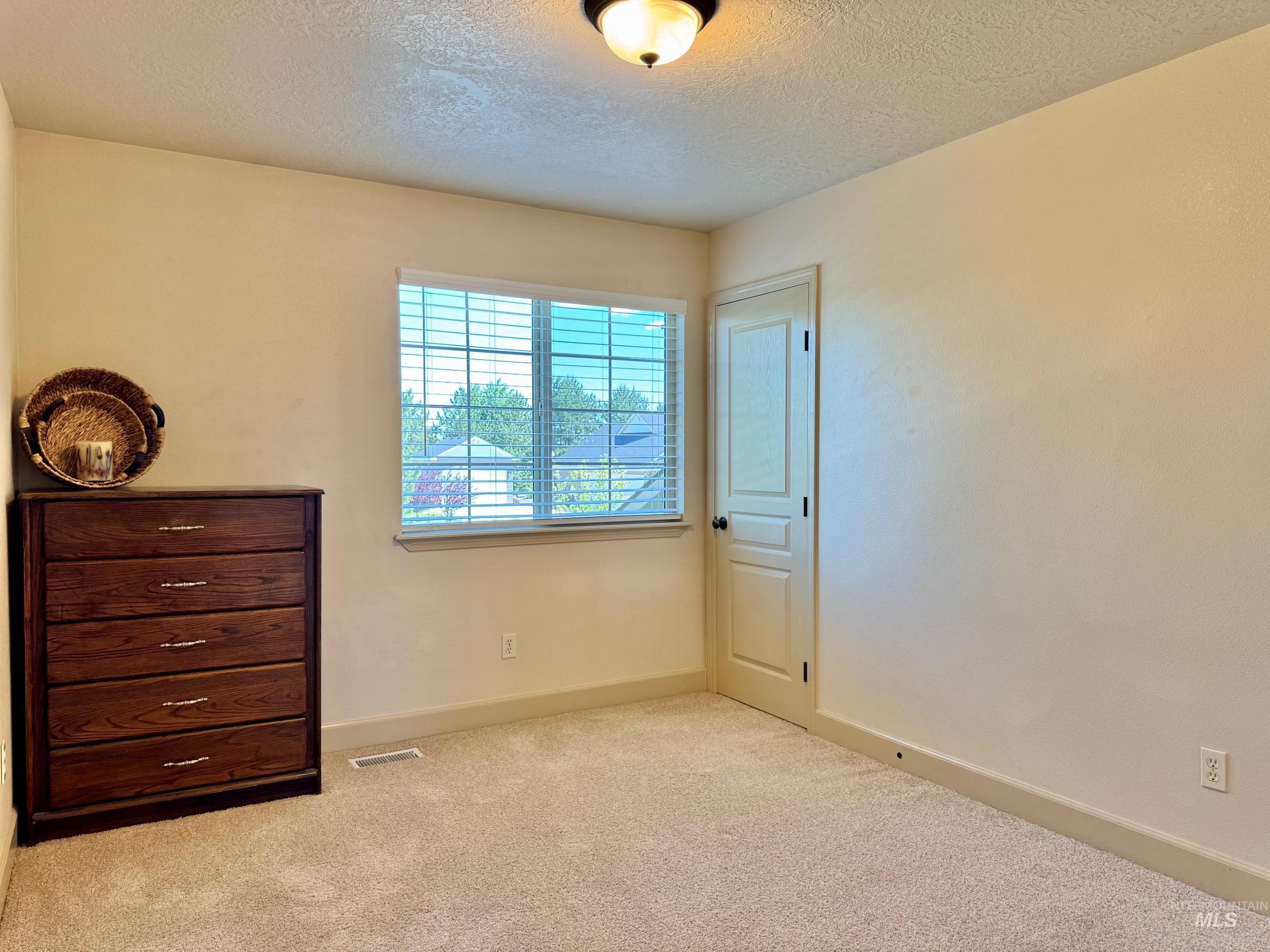 9299 Kemp Road Middleton, ID 83644 - Photo 34 of 50 Bedroom featuring plush neutral-toned carpeting, a window with blinds, and painted baseboards