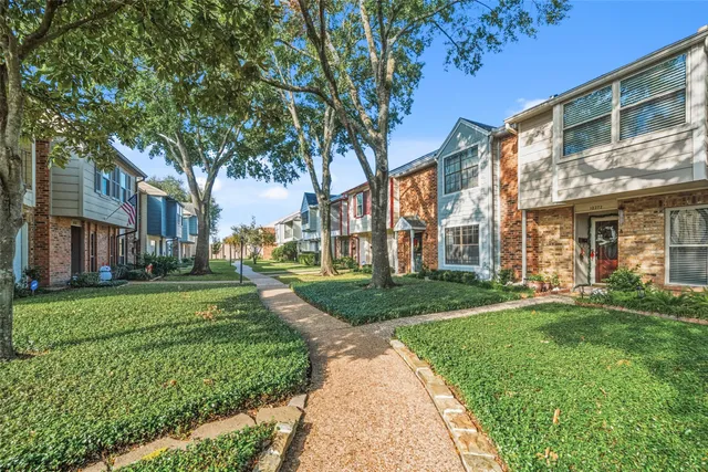 front view of a brick house with a yard