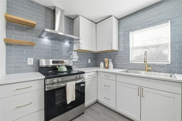 a kitchen with white cabinets and a stove top oven