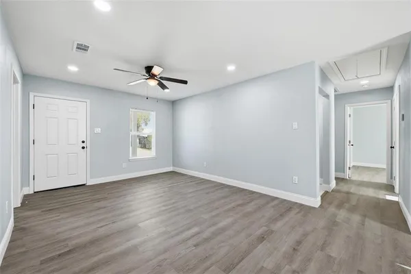 an empty room with wooden floor and windows