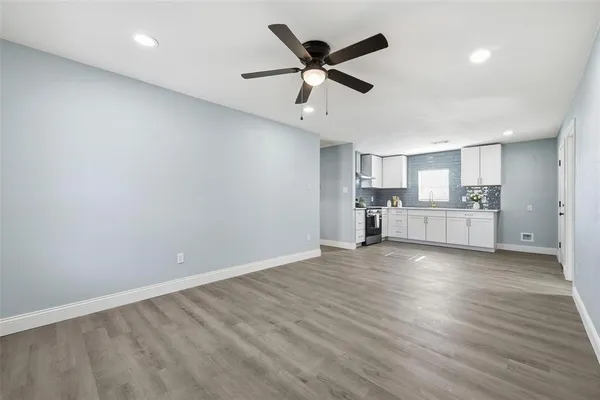 a kitchen with stainless steel appliances a sink a window and white cabinets