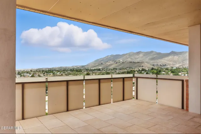an empty room with chandelier fan and windows