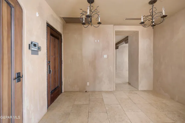 an empty room with wooden floor and fan