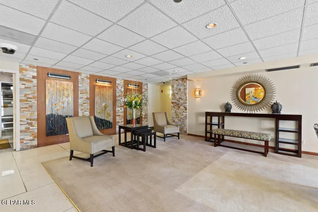 a view of a hallway with windows and chandelier