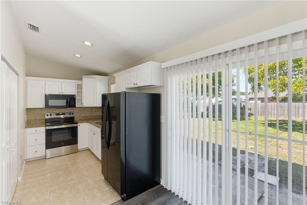 5283 17th Place Southwest Naples, FL 34116 - Photo 11 of 20 a kitchen with stainless steel appliances granite countertop a refrigerator and a stove