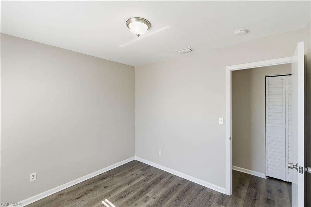 5283 17th Place Southwest Naples, FL 34116 - Photo 12 of 20 an empty room with wooden floor and windows