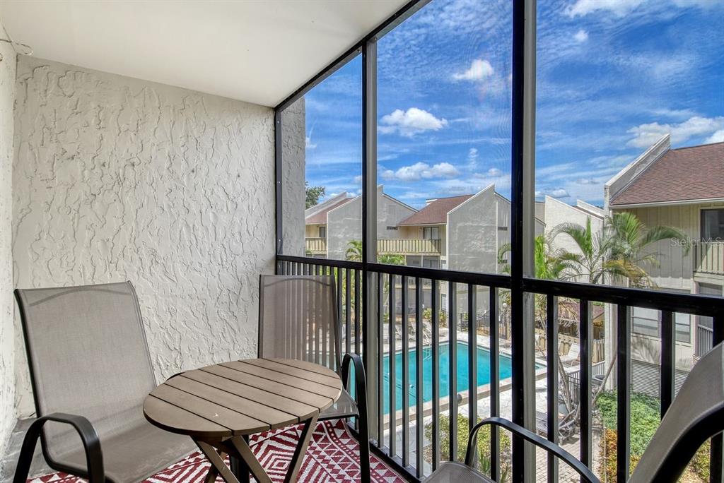 6157 Midnight Pass Road, Unit E63 Sarasota, FL 34242 - Photo 12 of 61 a view of a balcony with chair and wooden floor