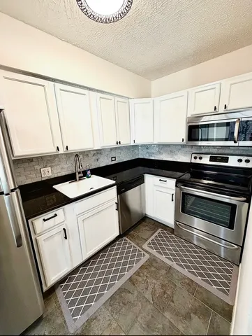 a kitchen with a sink stove and cabinets