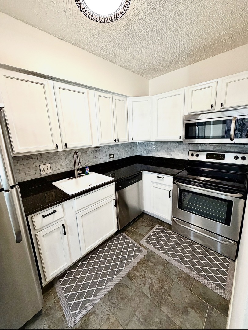 1550 North Lake Shore Drive, Unit 9F Chicago, IL 60610 - Photo 2 of 19 a kitchen with a sink stove and cabinets