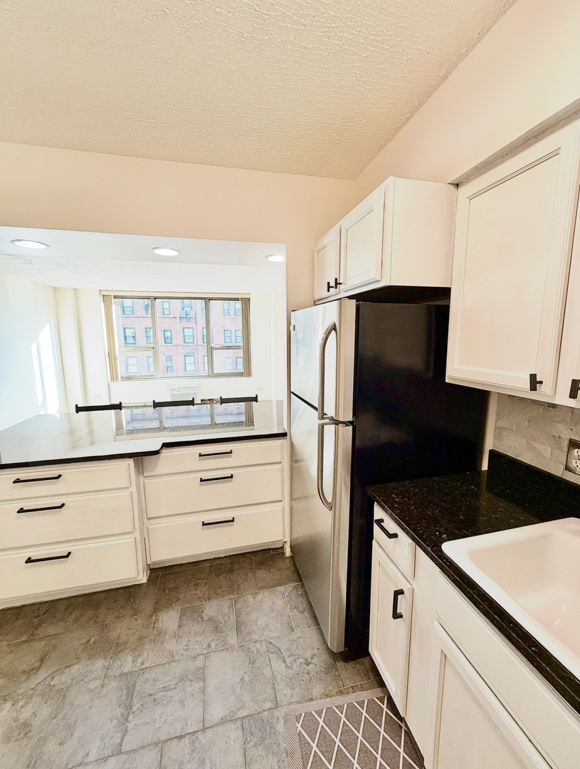 1550 North Lake Shore Drive, Unit 9F Chicago, IL 60610 - Photo 3 of 19 a kitchen with a refrigerator and a sink