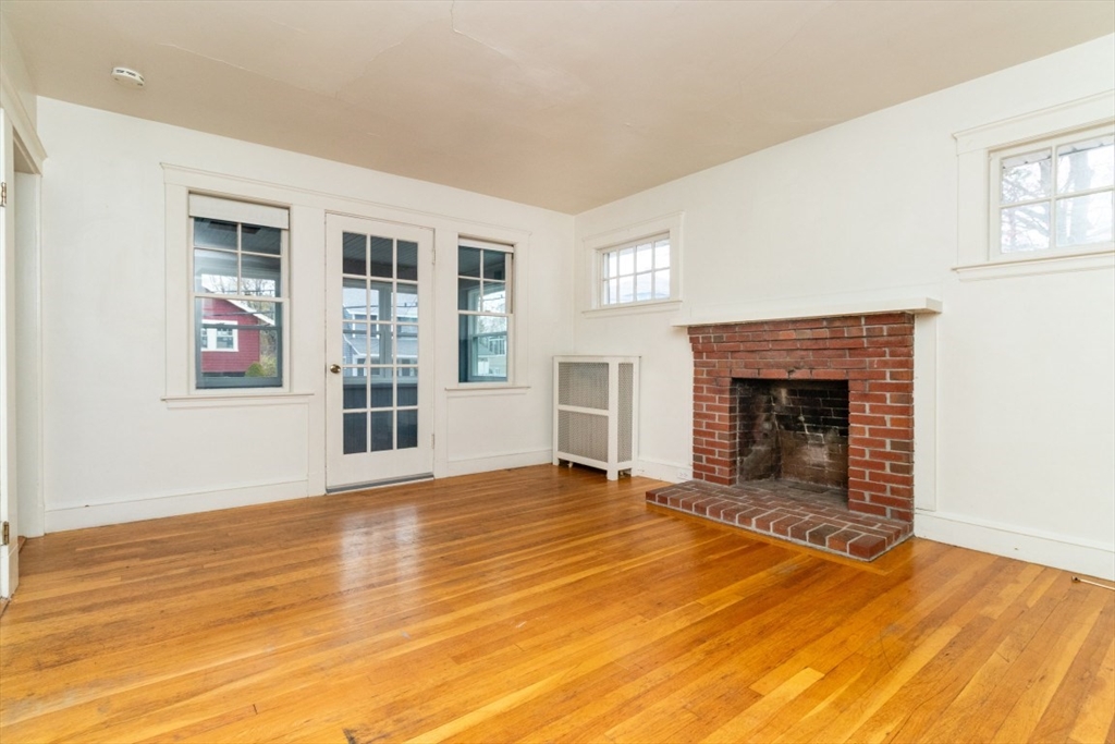 151 Pine Street, Unit 2 Quincy, MA 02170 - Photo 2 of 11 a view of empty room with wooden floor and fireplace