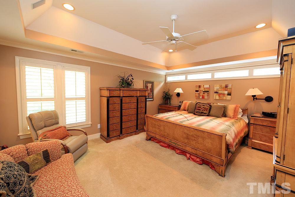 2023 Landings Way Raleigh, NC 27615 - Photo 17 of 25 a bedroom with a large bed and a chandelier