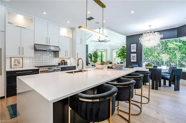 a kitchen with a table chairs sink and cabinets
