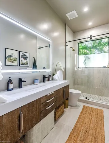 a en suite bathroom with double vanity sinks a large mirror and a shower