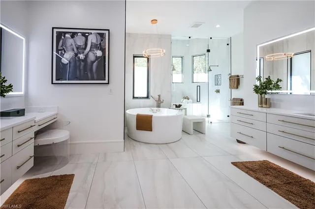 a large white room with mirror and view of bathroom