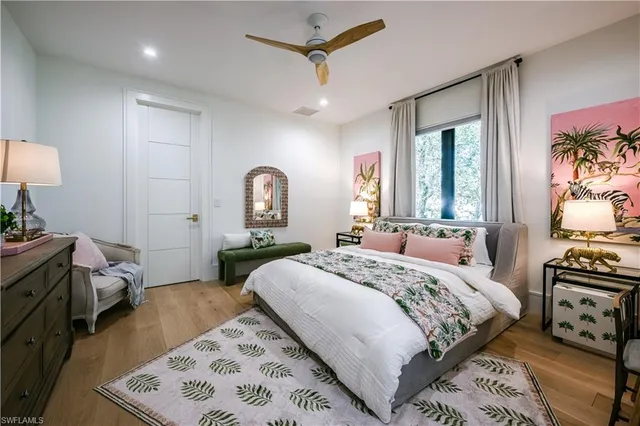 a bedroom with a bed a mirror on dresser and a window