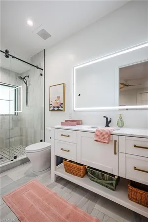 a bathroom with a double vanity sink toilet and shower