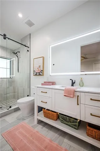 a bathroom with a double vanity sink toilet and shower