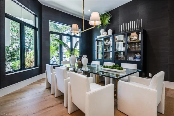 a dining room with furniture a chandelier and wooden floor